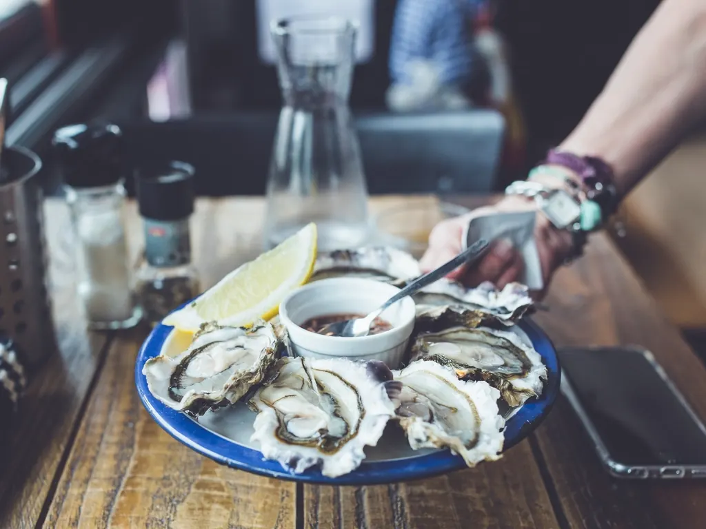A plate of opened oysters with lemon and shallot vinegar