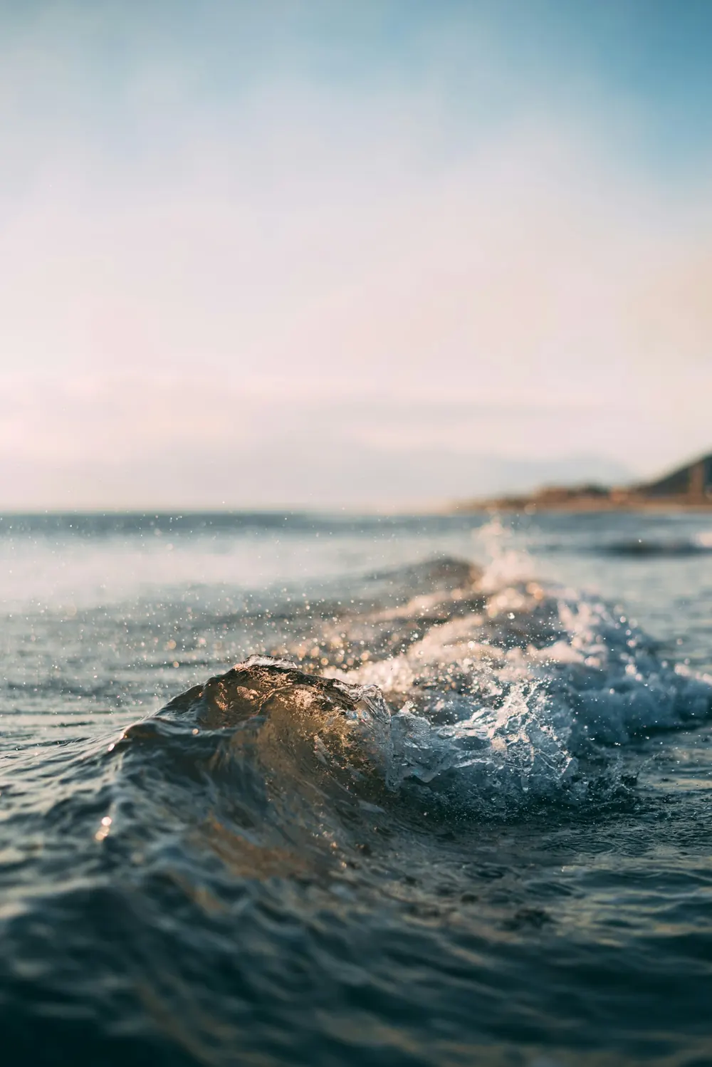 A small wave breaking in cold green water